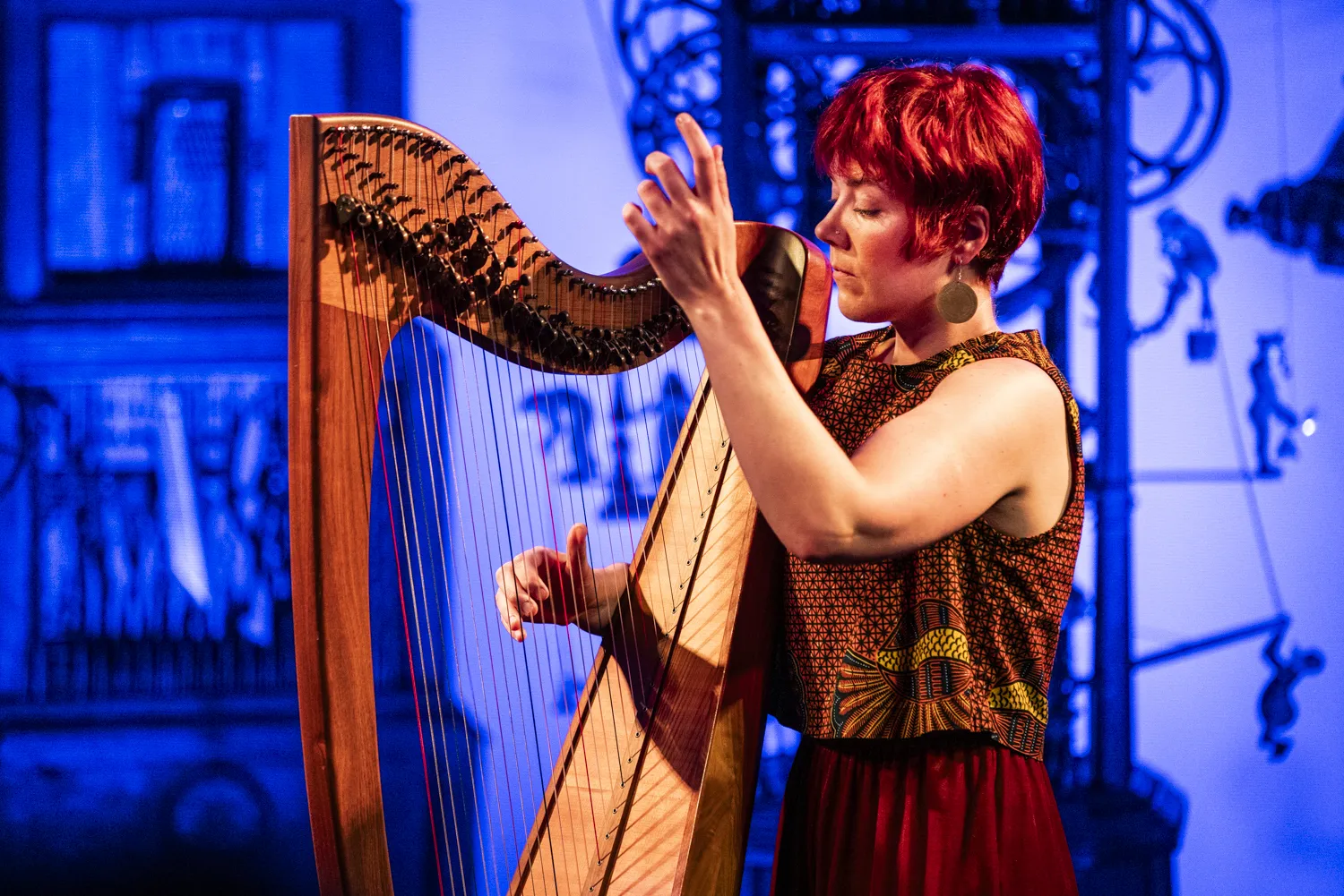 Harpist performing against blue background